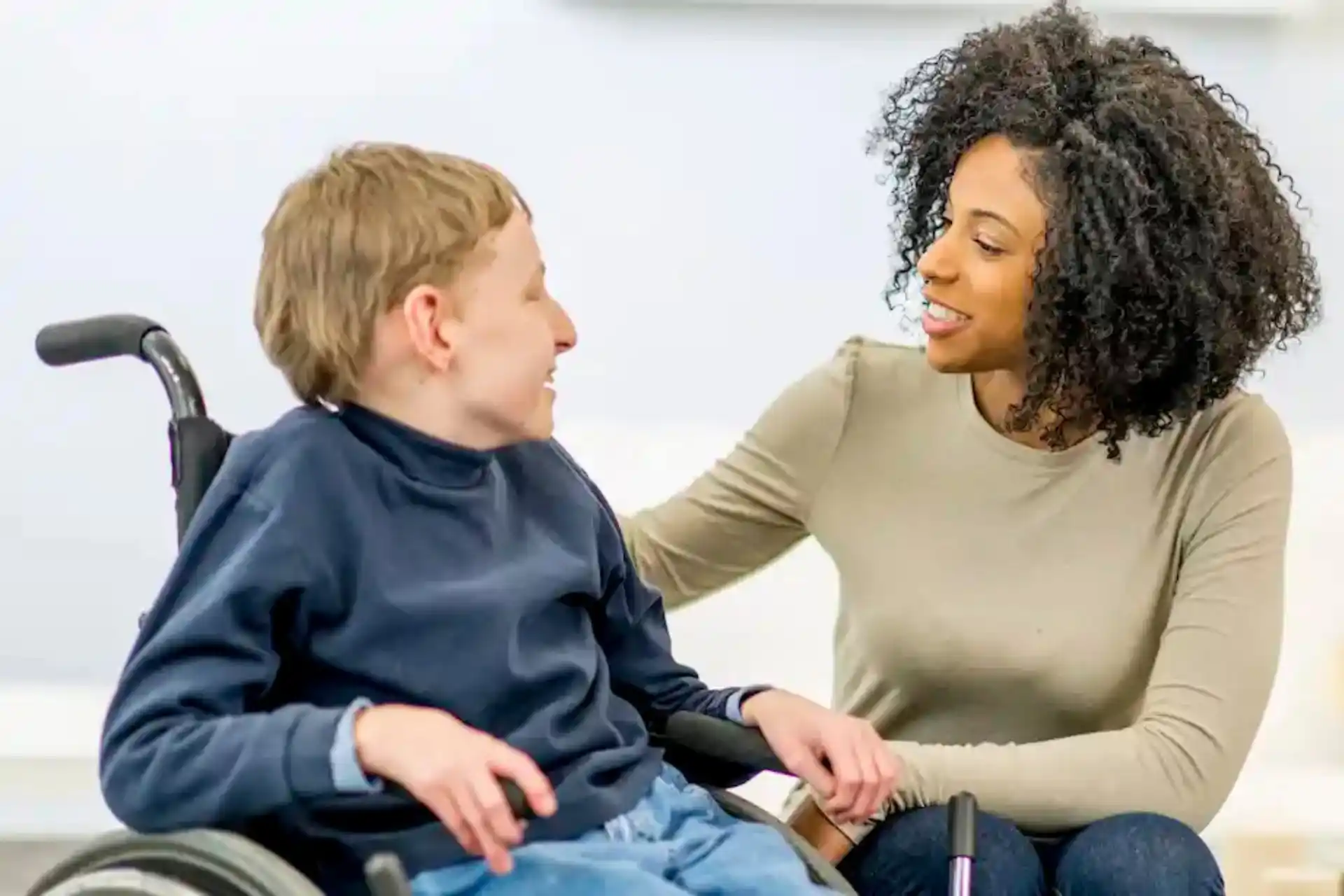 Support Co-ordinator providing NDIS Plan Support to participant in wheelchair with care and encouragement.